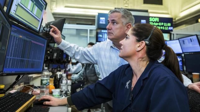 In this photo provided by the New York Stock Exchange, a pair of traders work on the floor, March 8, 2022. (Courtney Crow/New York Stock Exchange via AP)